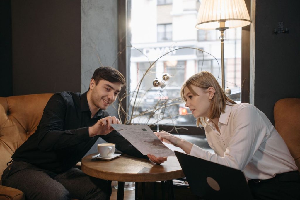 Two people talking through a plan over coffee